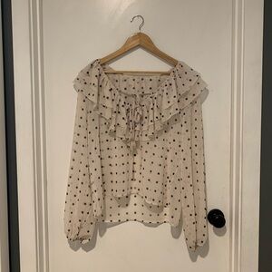 Girly cream and black polka dot sheet top with ruffle collar and tie details.